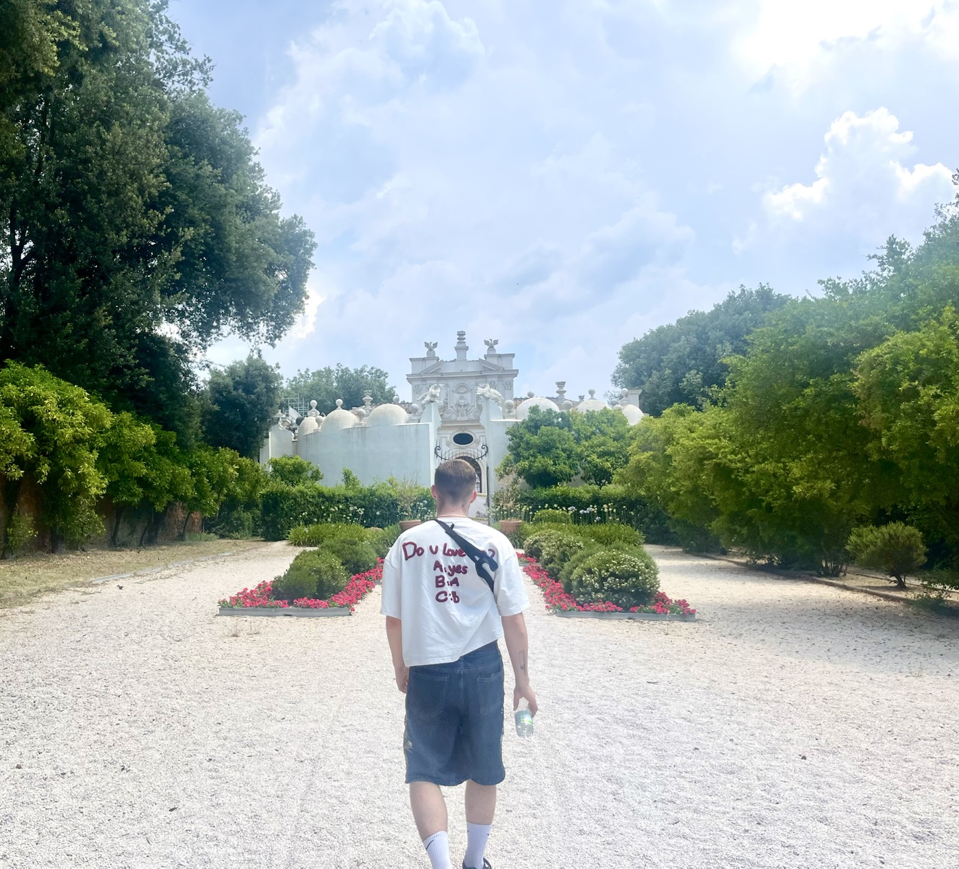 Finley Nye walking through a garden toward a historic building